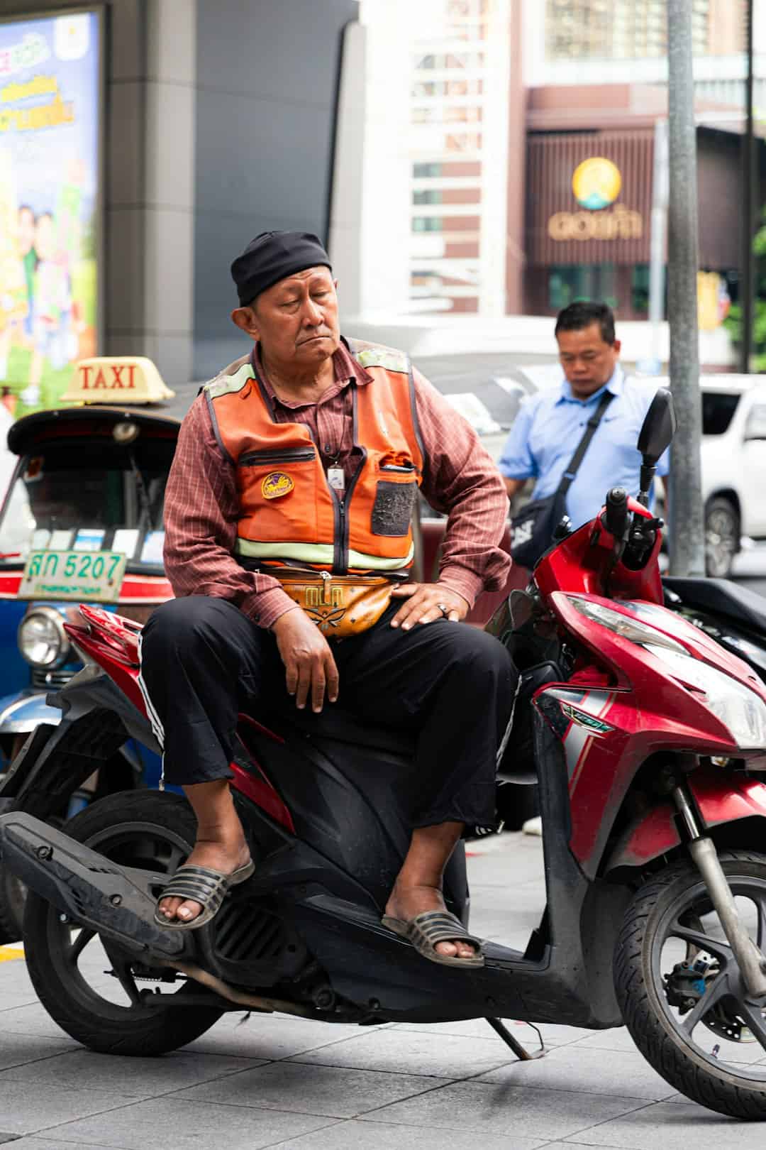 Photo by Nathanaël Desmeules Motorbike taxi orange vest Bangkok soi