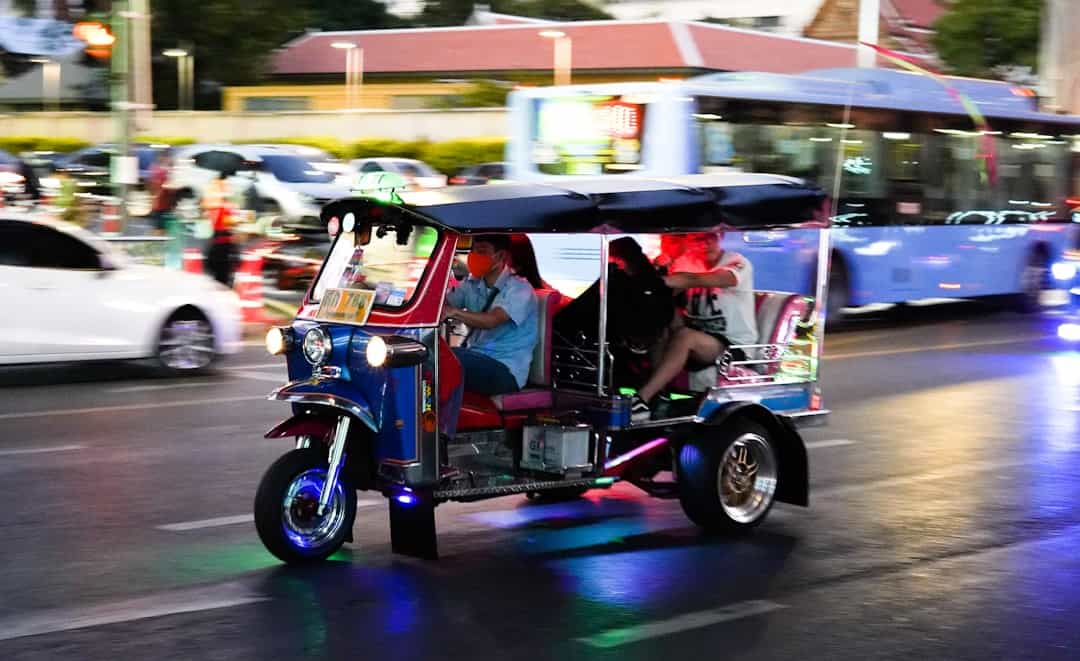 Photo by Yuya Uzu 2 people riding on blue and white TukTuk
